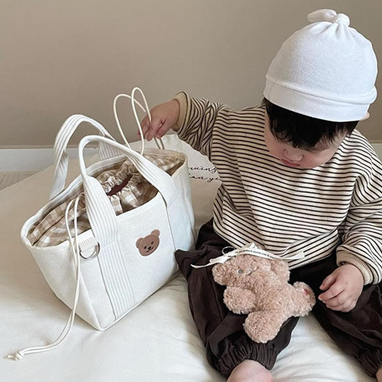 bebe jouant avec sac a langer blanc lunamade carrousel